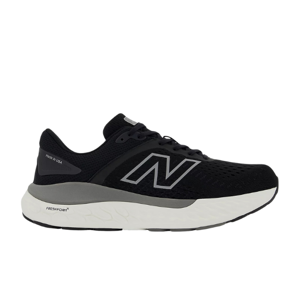 The New Balance Womens Fresh Foam X 1540v4 Wide in Black/White features a mesh upper, grey accents, signature N logo, and a cushioned Fresh Foam X midsole for optimal running comfort.