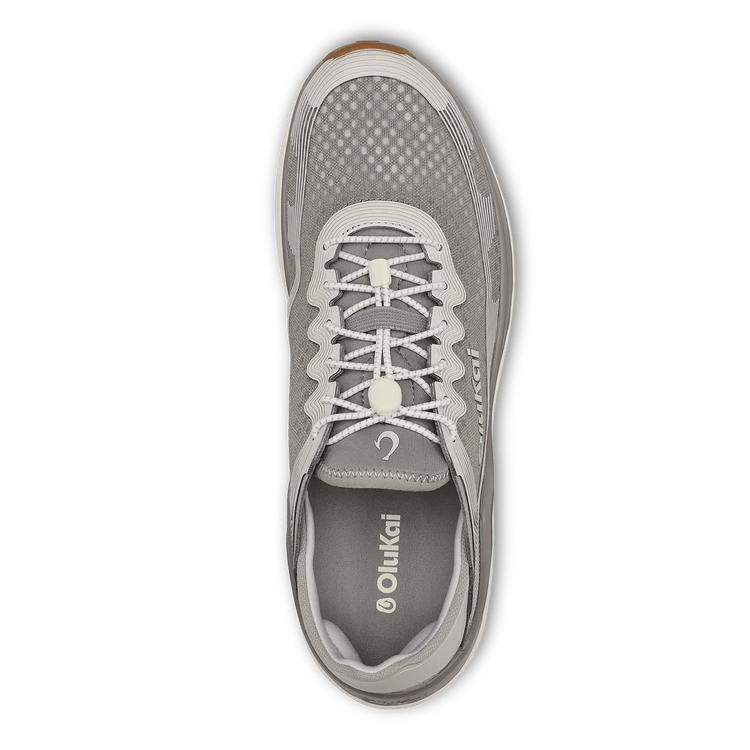 Top view of the Olukai Mens Ahi Ash/Sterling by OLUKAI—a gray athletic shoe with white laces, mesh upper, and branded insole, designed for barefoot comfort and perfect as waterman footwear.
