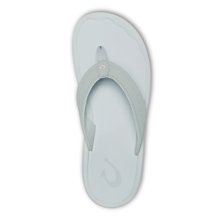 A single OLUKAI Womens Ohana sandal in Cloud Grey with a water-resistant, contoured footbed, dark sole, and simple thong strap is shown from above on a black background.