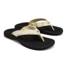 The OLUKAI Womens Ohana Toasted Coconut sandals feature cream-colored floral straps and black soles. These water-resistant flip-flops offer a comfortable, casual design with an anatomical footbed for all-day support.