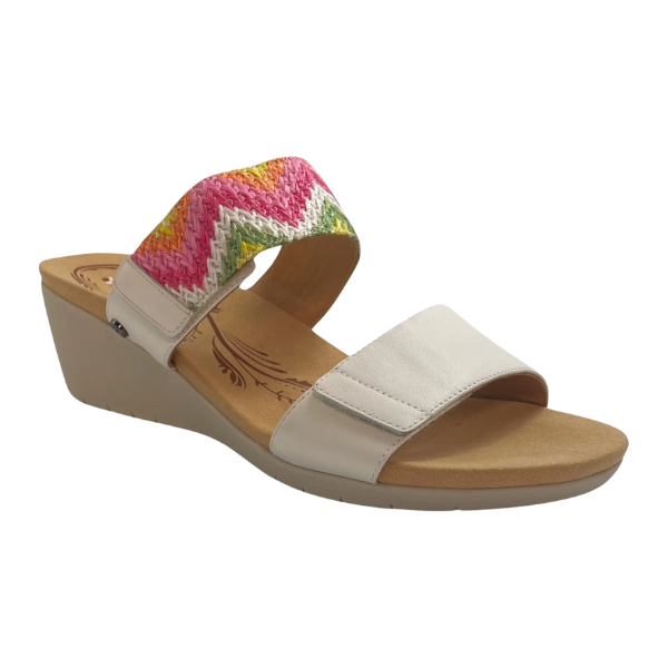 The Revere Womens Sorrento White by REVERE is a stylish wedge sandal with a beige sole, plain beige front strap, and colorful zigzag-patterned ankle strap. Its open-toe design features a low wedge heel for comfort and foot pain relief all day.