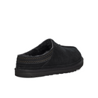 The UGG Mens Neuman Slipper Black features black suede, a low back, visible UGGpure wool lining, patterned trim, and a textured Treadlite by UGG rubber sole, shown from a rear side angle.