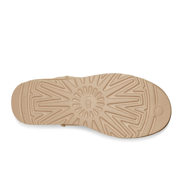 The image shows the tan sole of the UGG Womens Classic Mini II Boot Mustard Seed, featuring a geometric tread pattern and the letter B in a circle at the center of the heel.