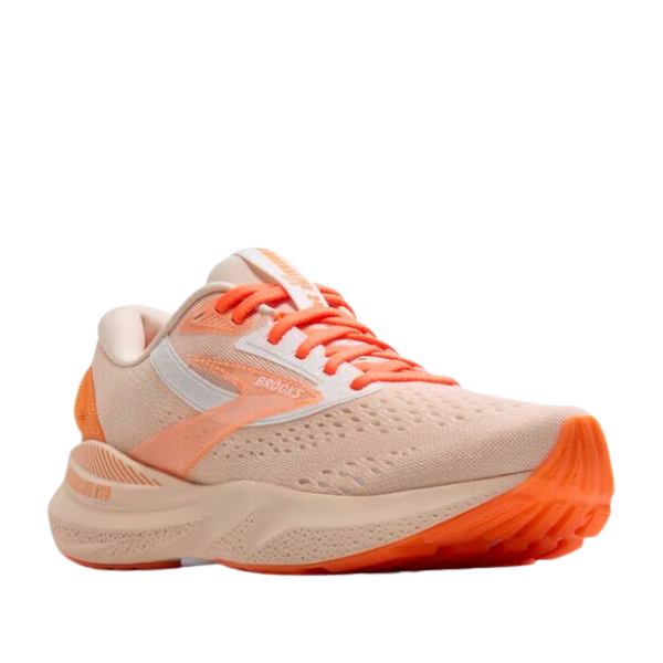The Brooks Womens Adrenaline GTS 24 Pink is a running shoe with a light peach mesh upper, white accents, orange laces, a cushioned sole, Brooks branding, and GuideRails® support for stability.