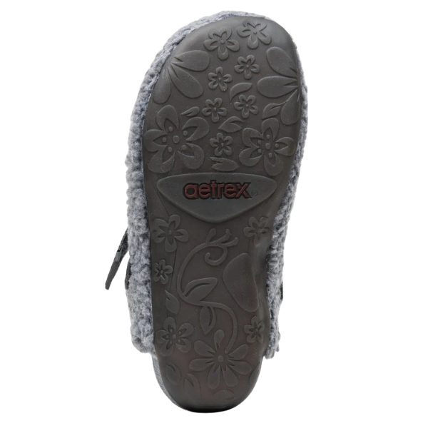 Close-up of a shoe sole with floral patterns and Aetrex branding on a white background