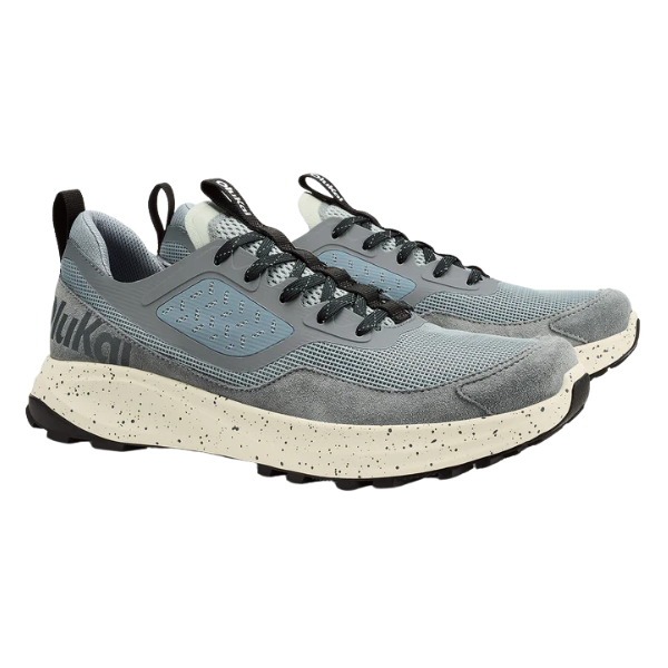 The OLUKAI Men's Makiki Grey sneakers feature gray and blue mesh and suede, black laces, a thick speckled off-white sole with black tread, a heel pull tab, and trail-ready traction for all-terrain performance.