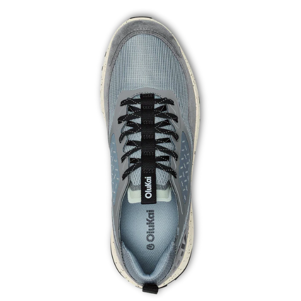 Top view of the OLUKAI Men's Makiki Grey, featuring black laces and a white speckled sole. OLUKAI branding appears on the tongue and insole, with trail-ready traction for all-terrain performance.