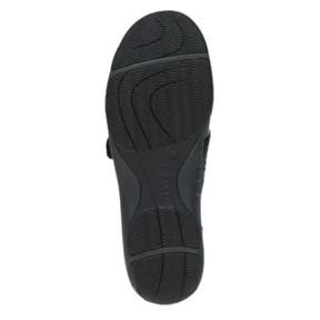 The image shows the black rubber sole of Dankso Women's Stacy Black by DANSKO, featuring a textured, wavy pattern for slip resistance. The brand name is embossed in the center. Set against a white background, it’s ideal for women seeking comfortable shoes.