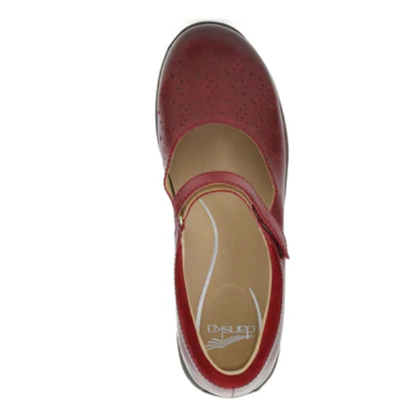 A top view of the Dansko Women's Stacy Red Mary Jane shoe features a perforated toe, instep strap, and branded beige insole with arch support, shown against a white background.