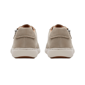 Rear view of HOKA Women's Transport 2 Wide Alabaster shoes with light beige uppers and white soles on white background.