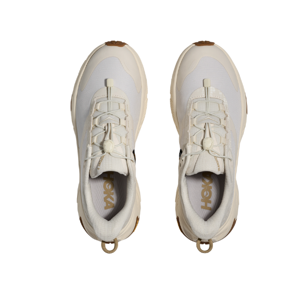 A pair of HOKA Women's Transport 2 Wide Alabaster running shoes, viewed from above on a white background.