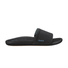 The OLUKAI Women's Ulele Slide Black features a thick strap, supportive footbed, and flat, water-ready sole.