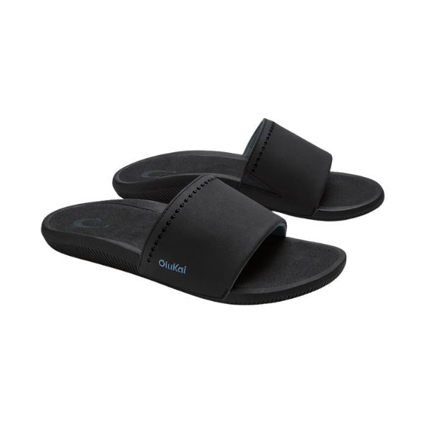 OLUKAI Women's Ulele Slide Black sandals with thick straps and supportive footbed, shown on a white background.