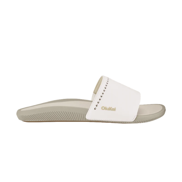 The OLUKAI Women's Ulele Slide White features a thick white strap, supportive footbed, and signature branding.