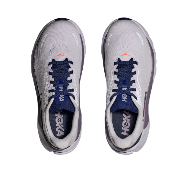 A pair of HOKA W Arahi 8 Starlight Glow/blue stability shoes with navy laces, viewed from above on white.