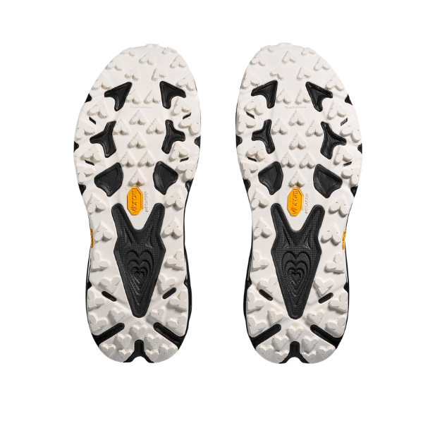 The HOKA Women's Speedgoat 7 Wide has white and black soles with rugged treads and yellow Vibram logos at the center.