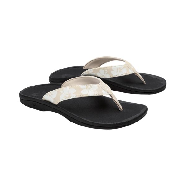 OLUKAI Women's Ohana Tapa black sandals with white and beige floral water-resistant straps.