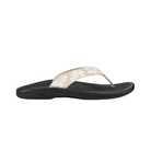A side-profile of the OLUKAI Women's Ohana Tapa sandal in beige and white with a black sole on a white background.