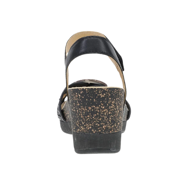 The Dansko Women's Stella Black is a black wedge sandal with a speckled cork heel, shown from the back.