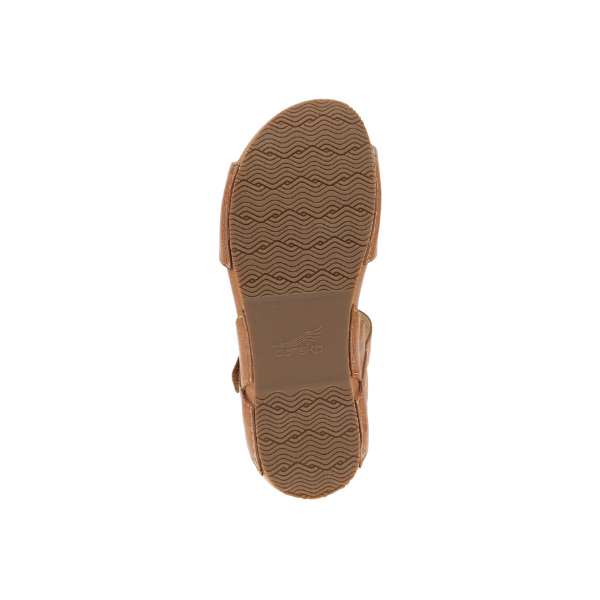 Dansko Women's Tinsley Natural sandal seen from below, displaying its tan rubber sole with a wavy tread pattern.