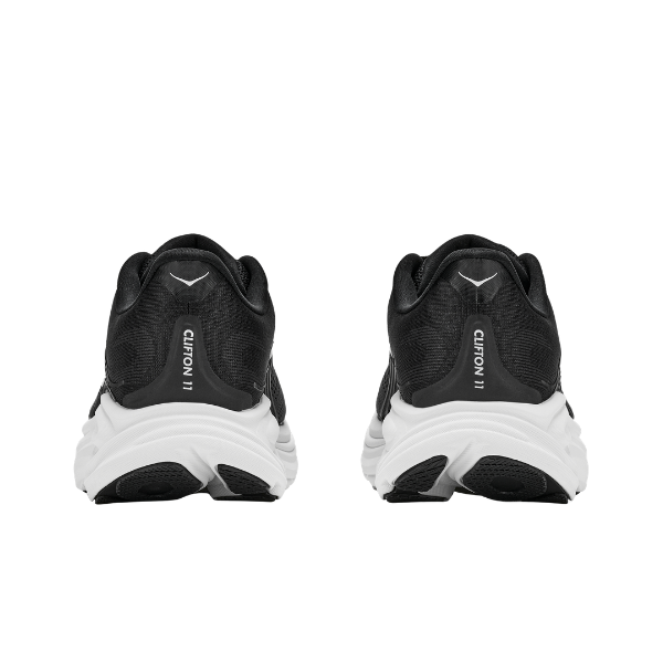 A pair of HOKA Women's Clifton 11 running shoes in Black/White, shown from the back.