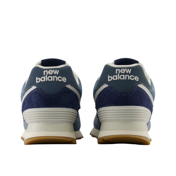 Back view of New Balance Women's 574 Blue/White sneakers with white soles and NEW BALANCE text on the heels.