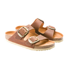 The Birkenstock Womens Arizona Big Buckle Cognac sandals by BIRKENSTOCK feature two large gold buckles and cork soles, crafted in oiled brown nubuck leather and displayed on a white background.