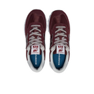 A pair of New Balance Unisex 574 Magenta shoes viewed from above, featuring white laces, white trim, and blue insoles with the NEW BALANCE logo.