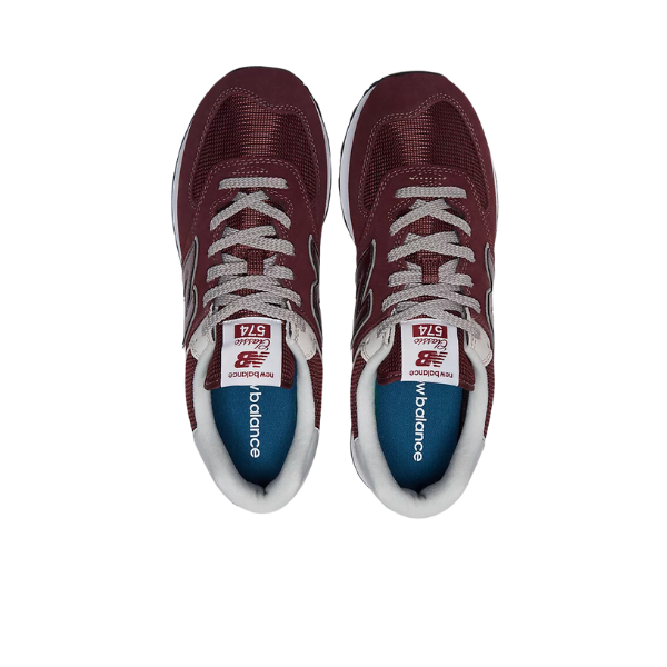 A pair of New Balance Unisex 574 Magenta shoes viewed from above, featuring white laces, white trim, and blue insoles with the NEW BALANCE logo.