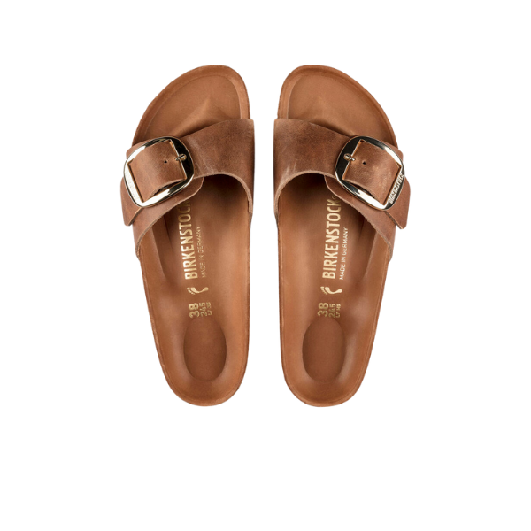 The BIRKENSTOCK Womens Madrid Big Buckle Cognac sandals feature a single Wide strap with a large metal buckle and the signature cork footbed, shown from above against a white background.