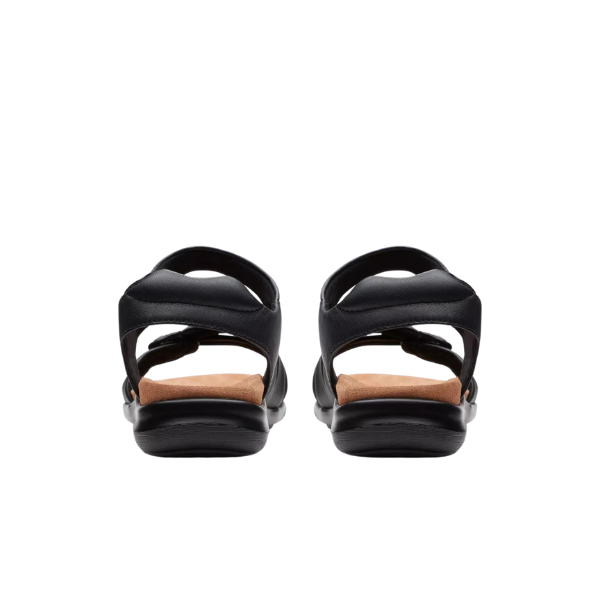 A pair of Clarks Womens Wide Kitly Ave Black Leather sandals by CLARKS, shown from the back with open heels, Contour Cushion tan insoles, and adjustable ankle straps against a white background.
