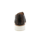 A rear view of the Django & Juliette Womens Onstage Black Leather shoe by DJANGO & JULIETT, featuring black perforated leather, a white sole, and brown trim, blends athleisure chic style with foot pain relief against a white background.