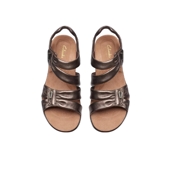 CLARKS Womens Kitly Ave Bronze sandals, featuring two adjustable straps, a peep-toe design, and a Contour Cushion footbed for comfort, are shown against a white background.