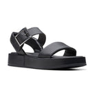 The Clarks Womens Alda Strap Black Leather sandal by CLARKS features a thick sole, Wide front strap, and adjustable ankle strap with silver buckle. Designed for comfort with a contour cushion footbed, shown from the front angle.