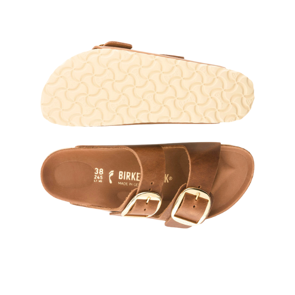 Birkenstock Womens Arizona Big Buckle Cognac sandals feature two gold buckles, a contoured footbed for pain relief, and a textured white sole. Size and BIRKENSTOCK brand markings are visible inside the top sandal.