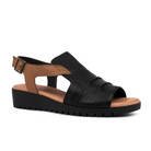 The Django & Juliette Womens Madis Black Leather sandal features a low black wedge sole, tan leather buckle strap, Wide black textured leather upper, open toe and heel, plus a soft leather footbed for lasting comfort.