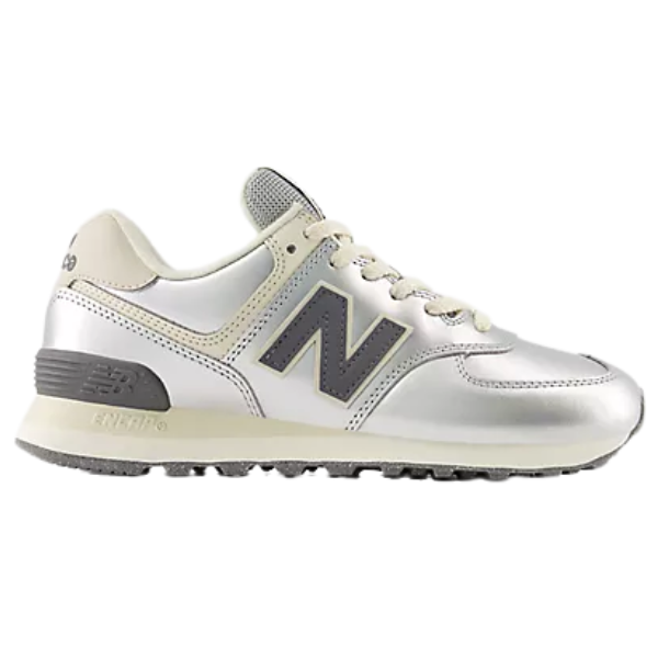 The New Balance Women's 574 in Metallic Silver/Arctic Grey features a gray N logo and black sole for stylish comfort.