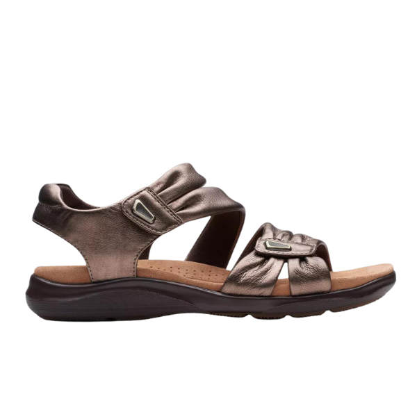 The Clarks Women’s Kitly Ave Bronze sandal by CLARKS features metallic bronze adjustable straps, a Contour Cushion footbed for comfort, and a dark brown sole—perfect for stylish, all-day support.