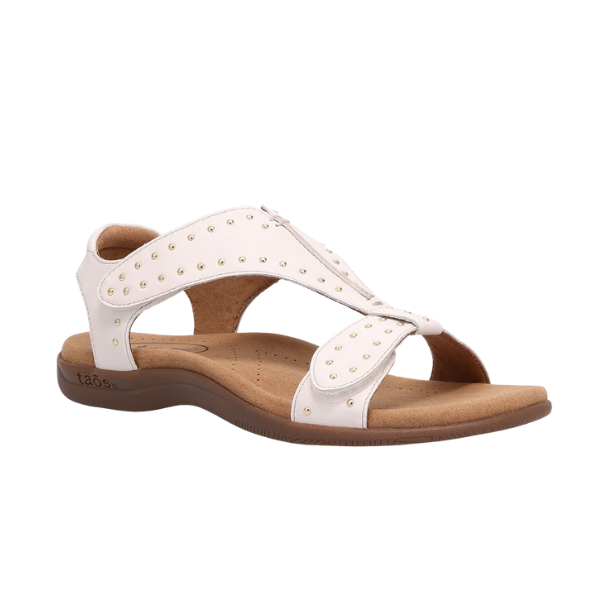 The TAOS Taos Womens Show Stopper Black sandal features an open toe, gold studs, adjustable ankle strap, cushioned tan footbed for pain relief, and a low brown sole.