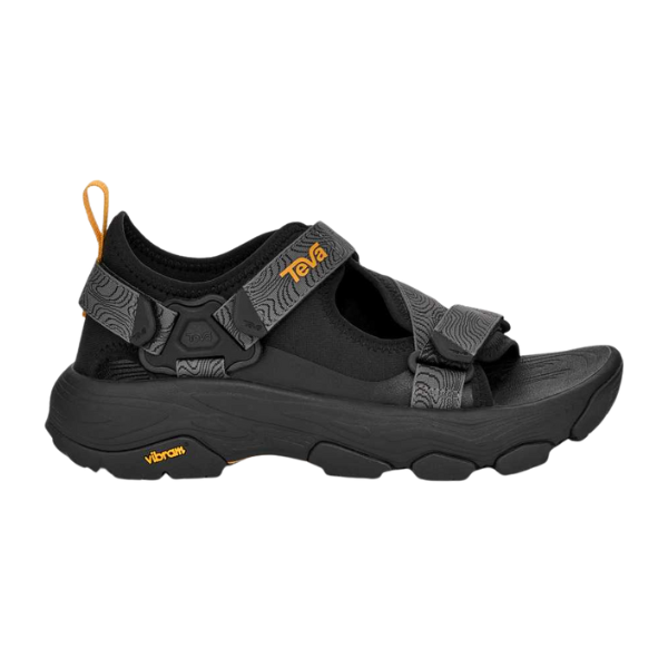 The Teva Mens Grandview Max Hiking Sandal features black textured straps, a thick sole, orange Teva logo, adjustable hook-and-loop closures with an Adjustable W Strapping System, and a Vibram MegaGrip outsole for superior traction.