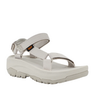 The Teva Womens Hurricane XLT2 Ampsole Moonstruck is a light gray sport sandal with a thick, rugged sole and adjustable Velcro straps, featuring the Teva logo on the side and made with recycled materials.