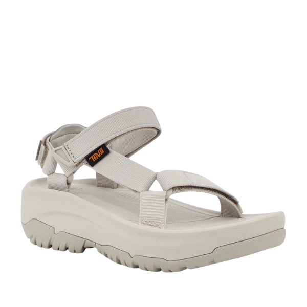 The Teva Womens Hurricane XLT2 Ampsole Moonstruck is a light gray sport sandal with a thick, rugged sole and adjustable Velcro straps, featuring the Teva logo on the side and made with recycled materials.