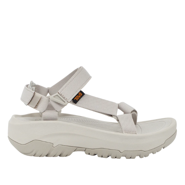 The Teva Womens Hurricane XLT2 Ampsole Moonstruck is a beige sport sandal with thick, textured sole, adjustable fabric straps with heel and ankle support, a side Teva logo tag, and is made from recycled materials.