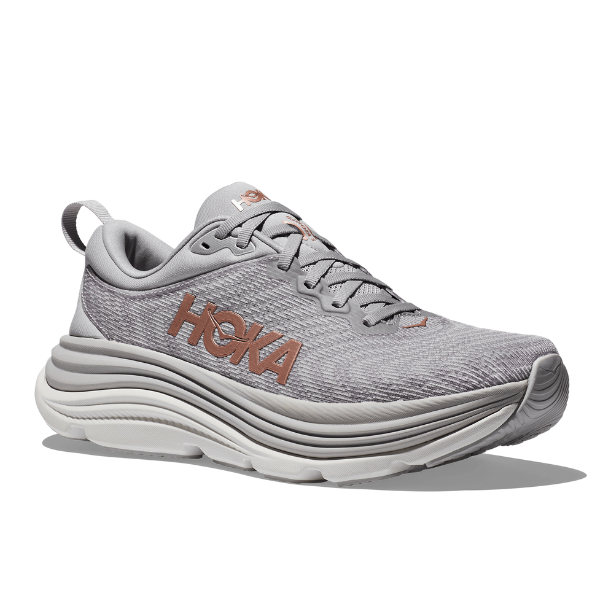 The HOKA Womens Gaviota 5 Wide in Harbor Mist/Rose Gold features a mesh upper, stabilizing H-Frame tech for support, a thick white/gray sole, tan HOKA logo, heel pull tab, and angled design for style and comfort.