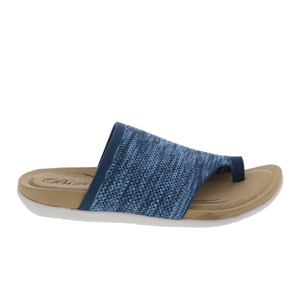 The Biza Womens Lavish Denim by BIZA FOOTWEAR features a blue and beige stretch knit upper, open toe, and white sole—photographed from the side on a white background. The ultimate travel sandal.