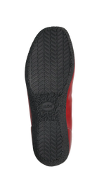 The image shows the black rubber sole of the TAOS Womens Chit Chat Red skimmer flat, featuring a herringbone tread pattern, tide embossed at the center, and a hint of red—ideal for those wanting orthotic-friendly footwear.